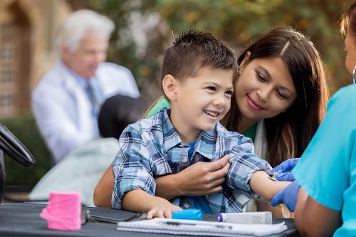 A woman holds a little boy on her lap.